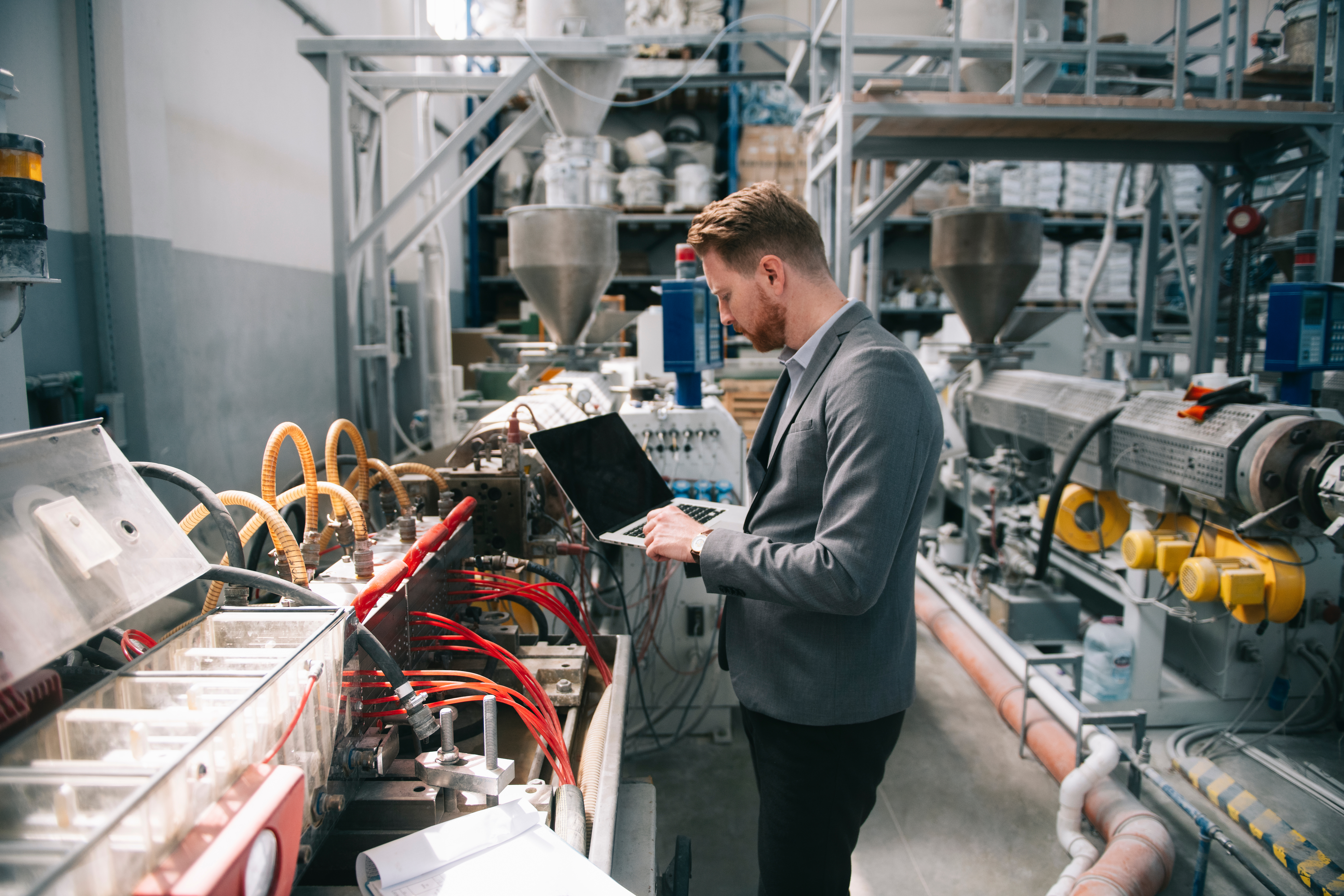 Man using laptop in manufacturing shop floor