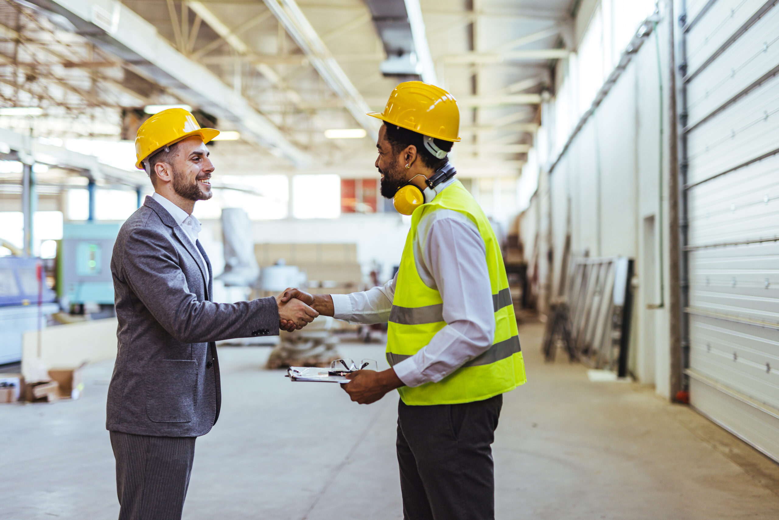 two manufacturing employees shaking hands