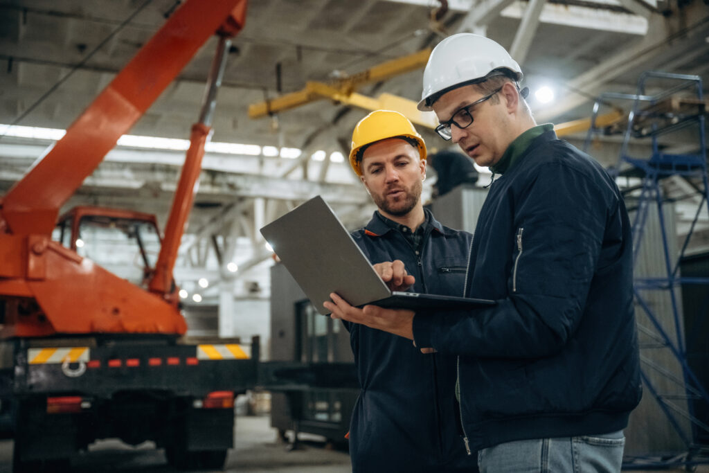 two factory workers looking at their laptop