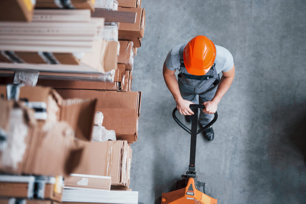 man in warehouse pushing boxes