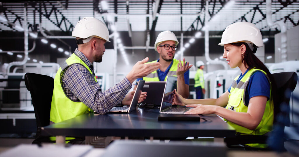 three manufacturing employees arguing looking at screens