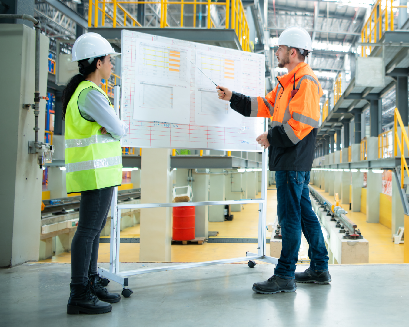 engineers looking at whiteboard schedule in manufactuirng