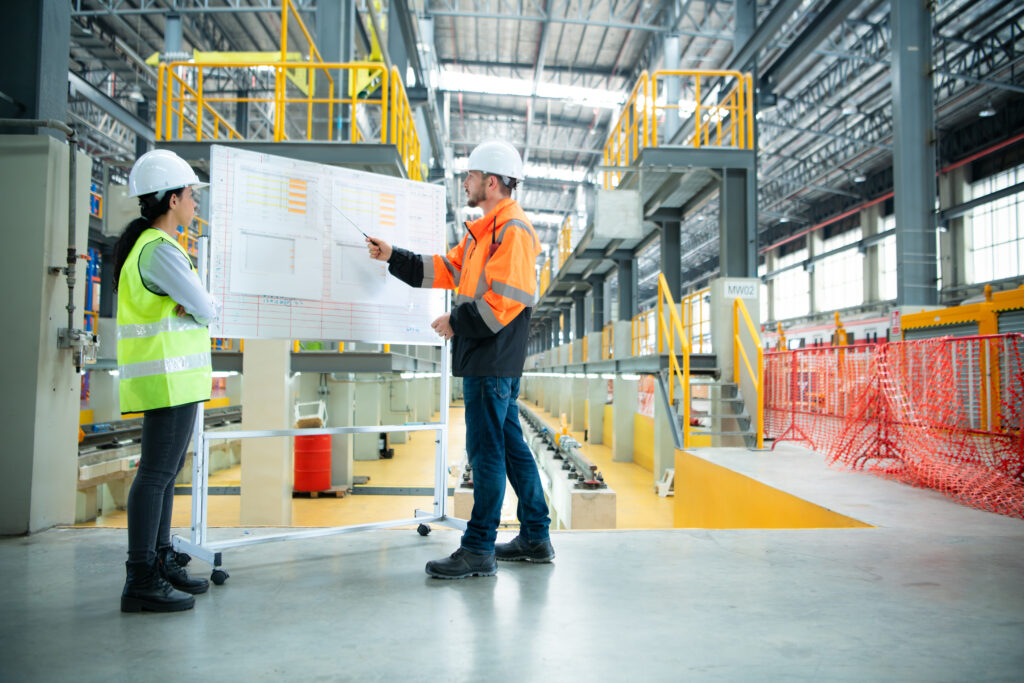 Male and female engineers work together in an electric repair station, Check the details of the electric train repair schedule.