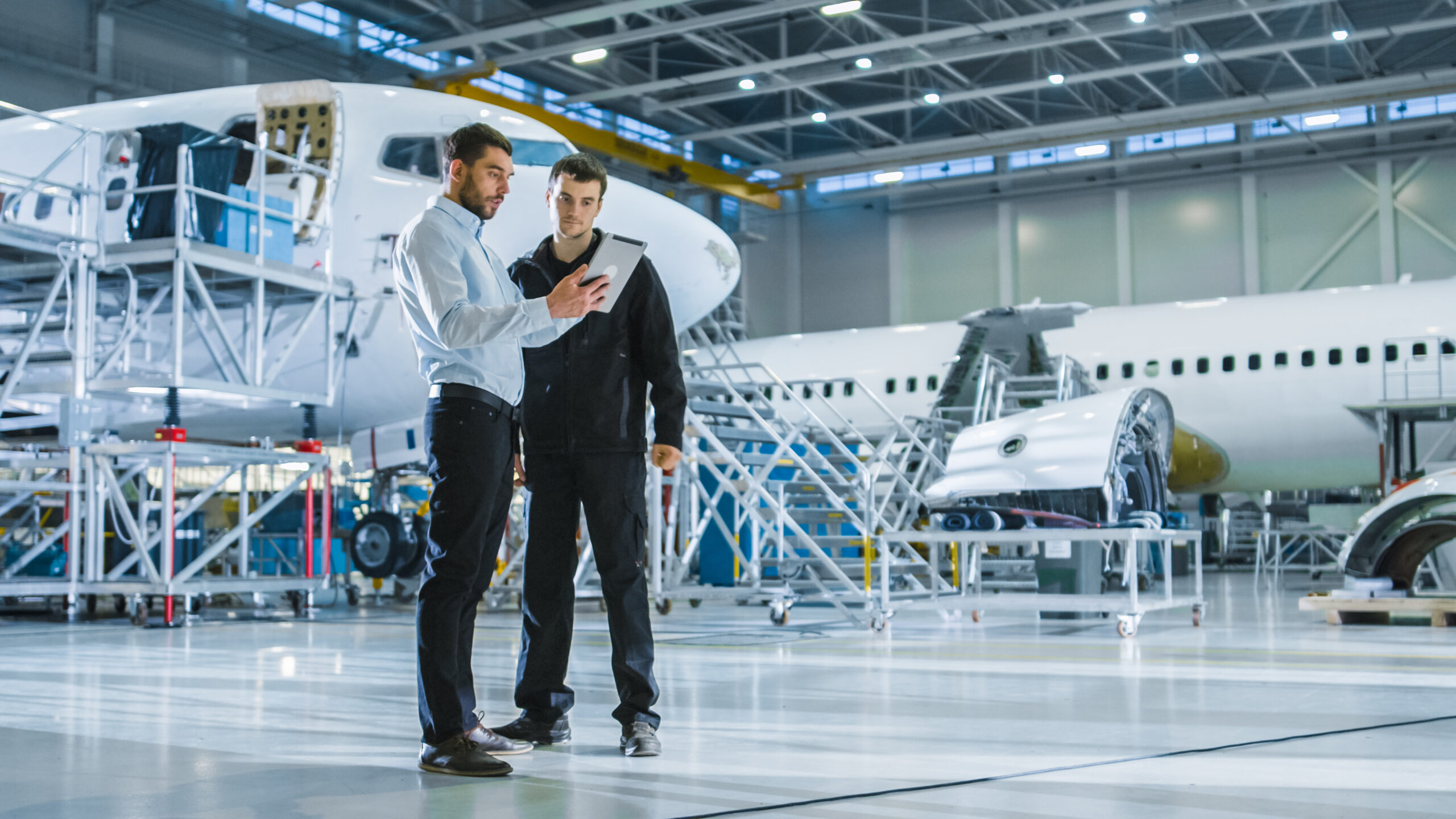 MRO technician and plant manager looking at tablet in warehouse